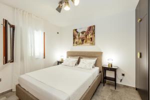a white bedroom with a bed and two tables at Albizia in Herceg-Novi +57 photos