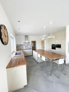 a kitchen with a table and a clock on the wall at Villa de standing en Champagne in Fresnes-lès-Reims +40 photos