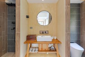 un bagno con lavandino e specchio di 问安民宿（黄山风景区店） a Mount Huangshan Altre 37 foto
