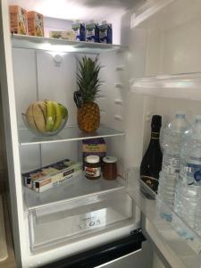 an open refrigerator with food and a pineapple and water at Casa Veranda sul mare in Gela +21 photos