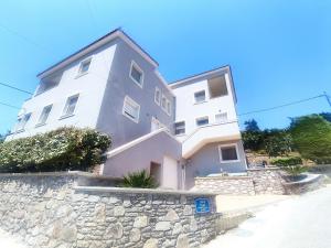 a large white building on a stone wall at Gea luxury apartment Myrina 2 in Myrina