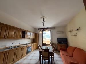 a kitchen with a table and a couch and a dining room at Appartamento villa Francesca in Castelluzzo +8 photos