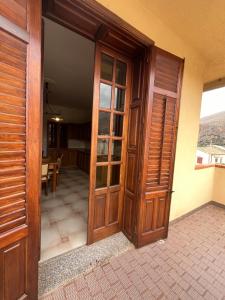 an open wooden door of a house with a dining room at Appartamento villa Francesca in Castelluzzo