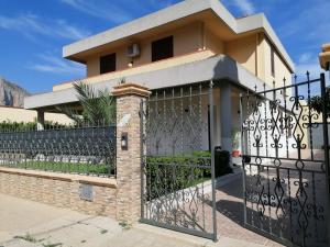 a house with a wrought iron gate at Appartamento villa Francesca in Castelluzzo