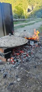 a fire pit with a bunch of ashes and a bench at Ekoo katun Jezerca in Vusanje