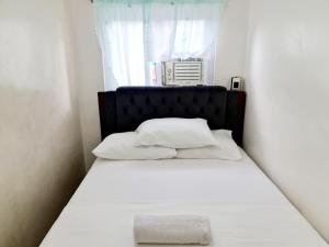 a bed with white sheets and pillows in a room at Vacation Transient Guest House Rental Calapan City L43 in Calapan +39 photos