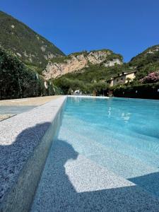 a pool of blue water with mountains in the background at Residence Cascata Varone in Riva del Garda