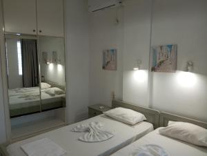 アギア・ペラギアにあるRenia Studiosのベッド2台と大きな鏡のある寝室