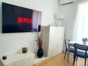 ein Wohnzimmer mit einem Fernseher an der Wand in der Unterkunft Lemon Sunshine Apartment in Ciampino