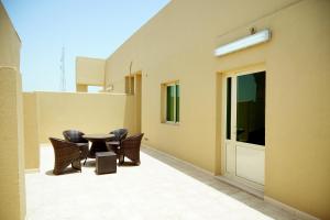 a patio with chairs and a table on the side of a building at ضيافة بيت المسرة للشقق المخدومة in Al Khobar