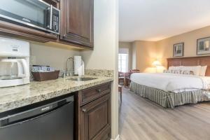 a hotel room with a bed and a kitchen at PetFriendly, 2 KingBeds, Gym, Pool, Netflix in Shanty Bay