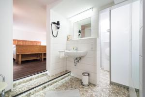 ein weißes Bad mit einem Waschbecken und einer Dusche in der Unterkunft Hotelpension Vitalis in Bad Hersfeld