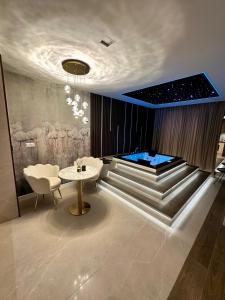 a room with a table and chairs and a tub at Masarska 8 VIP Apartamenty JACUZZI in Kraków