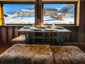 a table in a room with a view of the snow at Casa Bosque Patagonia in Villa Cerro Castillo