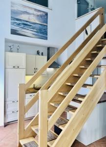 een houten trap in een keuken met witte kasten bij OstseeFreiheit in Bodstedt
