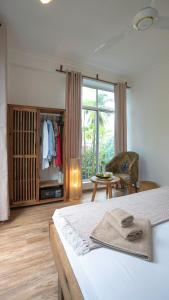 a bedroom with a bed and a chair and a window at Hi Zanzibar in Paje +24 photos