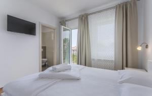 a bedroom with a white bed with a window at Villa Gloria 2 in Kukci +19 photos