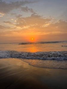 a sunset on a beach with the ocean at Apartamento en Huanchaco in Huanchaco