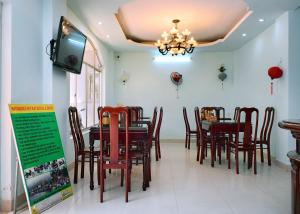 a dining room with a table and chairs and a tv at NHAT LE Hotel in Hue