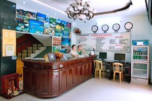 two people sitting at a bar in a restaurant at NHAT LE Hotel in Hue