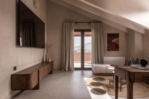 a living room with a couch and a table at Kokkinochoma Slow Living Villa in Lagópodhon