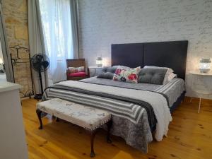 a bedroom with a large bed and a chair at Manoir Demouret Sarlat in Sarlat-la-Canéda