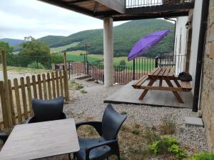 a picnic table with a purple umbrella and chairs at Palacio de Aralar Terracita in Oskotz +1 photo