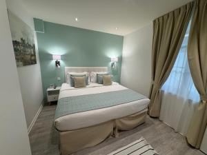a bedroom with a large bed in a room at Kyriad Saumur Hyper Centre Hôtel Appartements et SPA soins Sothys Paris in Saumur