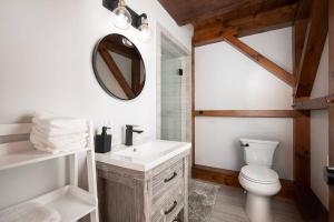 a bathroom with a sink and a toilet and a mirror at RIVER! Hot tub, Movie theater, Sauna, Massage chair in Conway +33 photos