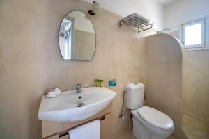 a bathroom with a sink and a toilet and a mirror at Olia Hotel in Tourlos