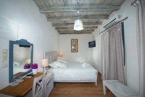 a bedroom with a bed and a desk and a mirror at Olia Hotel in Tourlos