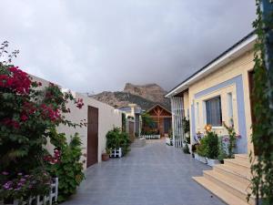 a street with flowers and buildings and mountains in the background at كوخ ريفي تنومة in Tanomah