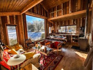 a living room filled with furniture and a large window at Casa La Lenga Patagonia in Villa Cerro Castillo