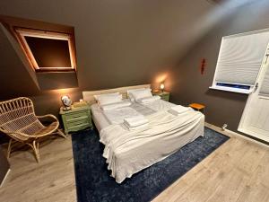 a bedroom with a large bed and a chair at Luxurious House with hot & cold tub in Reykjavík +41 photos