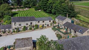 an aerial view of a large stone house with a driveway at Bolehill Farm Cottages in Bakewell