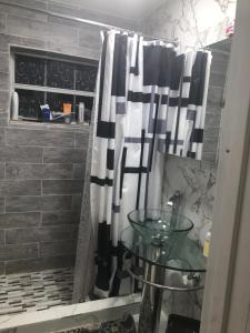 a shower curtain in a bathroom with a glass table at Josiane Peace of stay in Miami