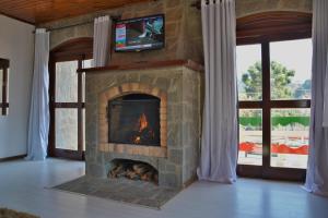 a stone fireplace with a television on top of it at Villaggio di Roma - Campos do Jordão in Campos do Jordão +11 photos