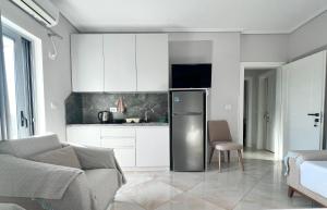 a kitchen with a stainless steel refrigerator in a living room at Prestige Home KSAMIL in Ksamil