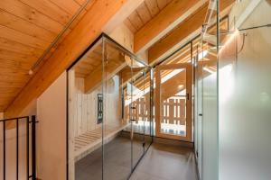 a glass corridor in a building with a wooden ceiling at Alpen Resort Bivio in Livigno