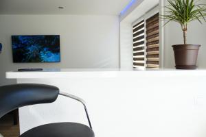 a white desk with a chair and a plant at Studio apartment in Valmiera