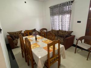 a dining room with a table and a couch at Beachfront Bliss Home Stay in Hambantota