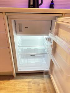 an empty refrigerator with its door open in a kitchen at Studio apartment in Valmiera +7 photos