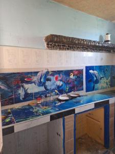 a kitchen counter with a painting of birds on it at L'Oasis Bleu D'Aourir in Aourir +7 photos
