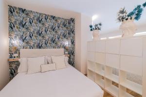 a bedroom with a large white bed with a floral wallpaper at Villa Mastrissa Taormina in Taormina +98 photos
