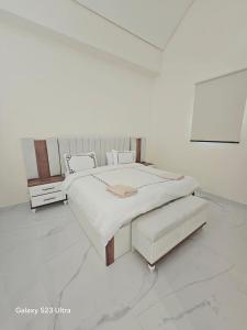 a white bedroom with a large bed in a room at B36 Loft Apartment Samarah Resort in Sowayma
