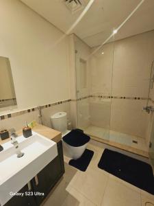 a bathroom with a shower and a toilet and a sink at B36 Loft Apartment Samarah Resort in Sowayma +22 photos