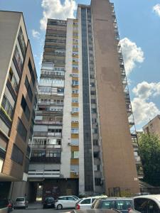 a tall building with cars parked in front of it at Appartment in Zenica +6 photos