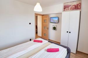 a bedroom with two beds with pink pillows at Marcos Apartments City Center - Self check-in in Reşiţa