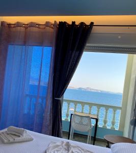 a bedroom with a window with a view of the ocean at Kalemi's Beachside Hotel in Sarandë