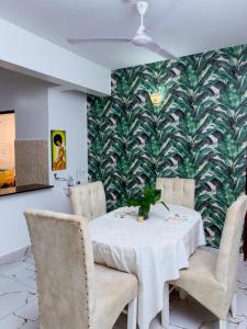 LN NYALI HOMESTAY ENSUITE ROOMs AND APARTMENT WITH SWIMMING POOL في مومباسا: غرفة طعام مع طاولة وكراسي وجدار متسخ